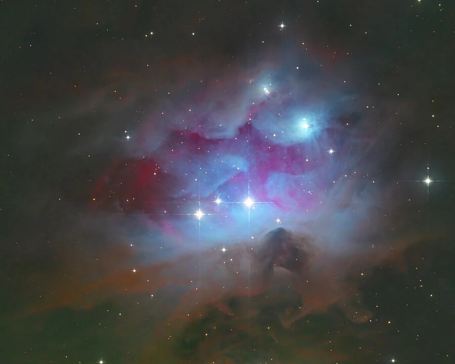 The Running Man Nebula, with luminous clouds and dark dust in Orion.
