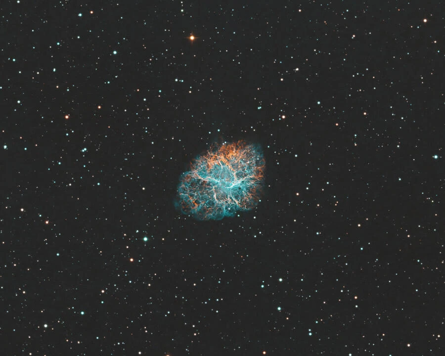 The Crab Nebula, a supernova remnant with intricate filaments of glowing gas.